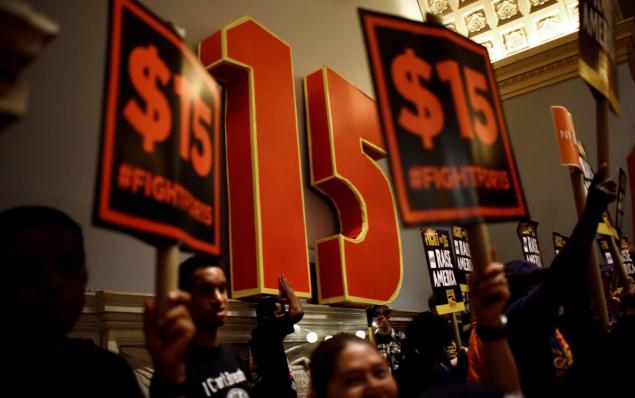 JUSTIN LANE  EPA  People chant during a rally calling for the minimum wage to be raised to $15 per hour before the convening of a Wage Board meeting