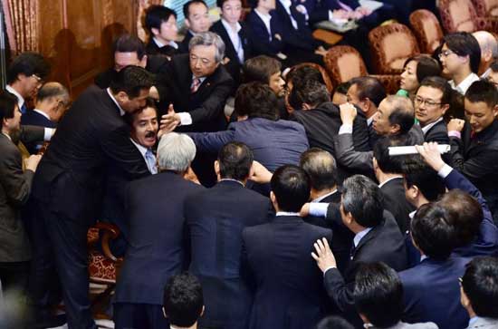 Opposition lawmakers rush towards acting chairman Masahisa Sato during the Upper House