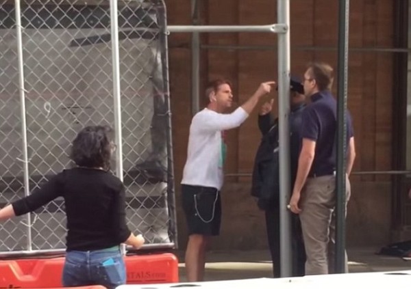 Jogger yells at man in khaki's, with black police officer in the middle. The irony alone is hysterical