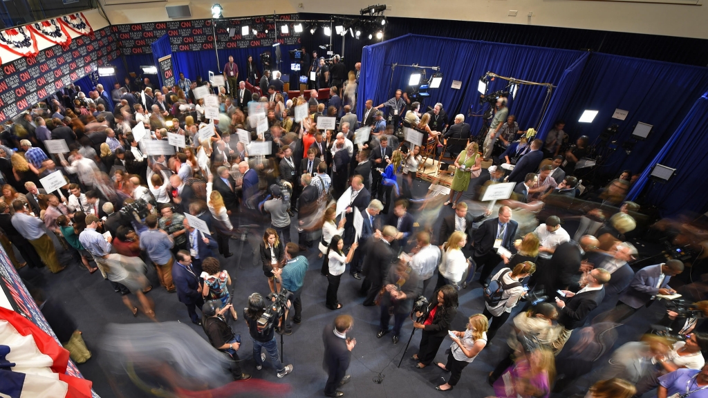 Journalists candidates and their representatives crowd the spin room after Wednesday night's debate