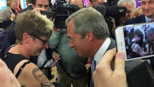 Kerrie Webb shows Ukip leader Nigel Farage her tattoo of his face during the Ukip annual conference at Doncaster Racecourse