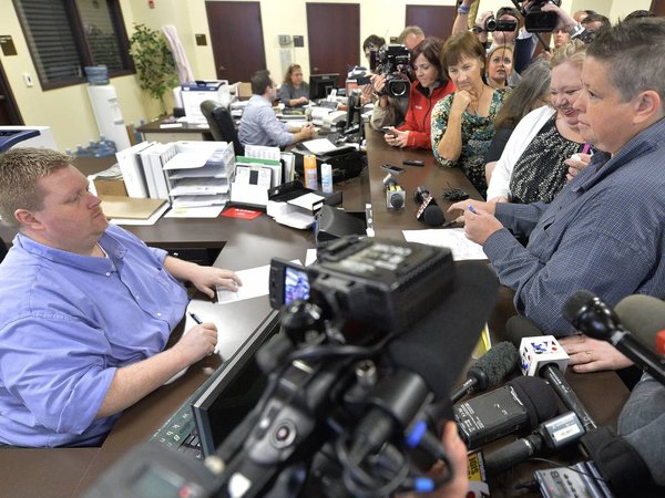 Rowan County Deputy Clerk Brian Mason left asks Shannon Wampler-Collins right and her partner Carmen Wampler Collins to double check their marriage license at the Rowan County Judicial Center in Morehead Ky. Monday Sept. 14 2015. Rowan County Clerk