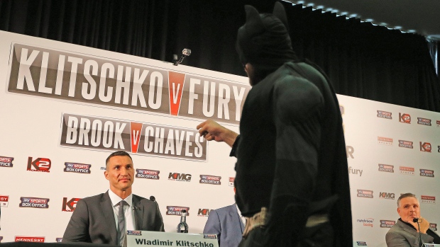 World Heavyweight boxing champion Wladimir Klitschko left is threatened by British heavyweight Tyson Fury dressed in a Batman costume during a press conference in London Wednesday Sept. 23 2015