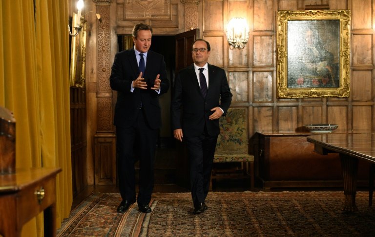 French President Francois Hollande talks with British Prime Minister David Cameron in the