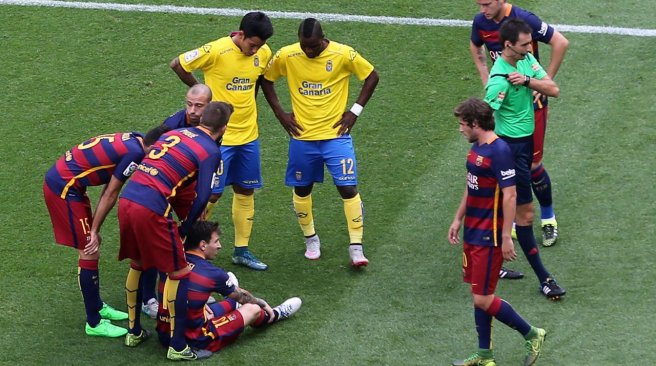 Barcelona forward Lionel Messi is surrounded by other players after being injured during the Spanish league football match FC Barcelona v UD Las Palmas at the Camp Nou stadium in Barcelona