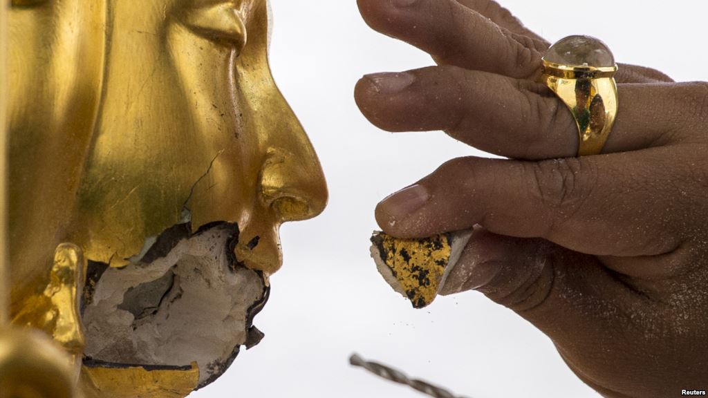 A craftsman fixes the statue of Hindu god Brahma after it was damaged during the deadly blast at the Erawan shrine in Bangkok Thailand