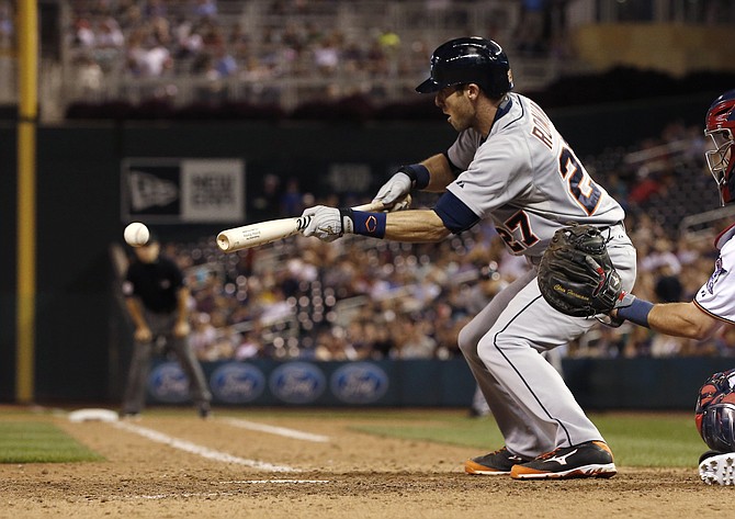 Detroit Tigers’ Andrew Romine hits a sacrifice bunt off Minnesota Twins pitcher Trevor May to drive in Tyler Collins in the ninth inning Tuesday in Minneapolis. The Tigers won 5-4