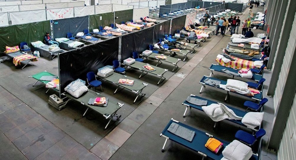 Refugees and migrants arrive in their accommodation the exhibition halls of the Trade Fair Messe Erfurt in Erfurt central Germany Tuesday Sept. 8 2015. The city of Erfurt expect up to 600 migrants to arrive within some hours