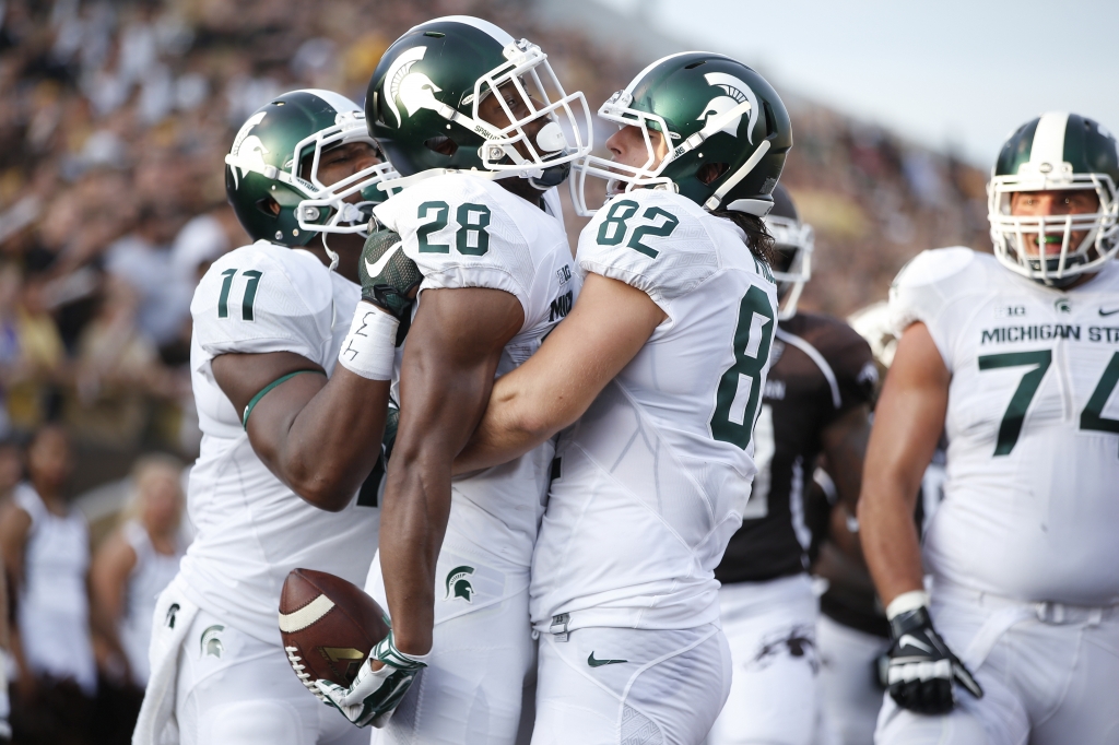 KALAMAZOO MI- SEPTEMBER 4 Madre London #28 of the Michigan State Spartans celebrates with teammates after a 24-yard touchdown run in the first half against the Western Michigan Broncos at Waldo Stadium