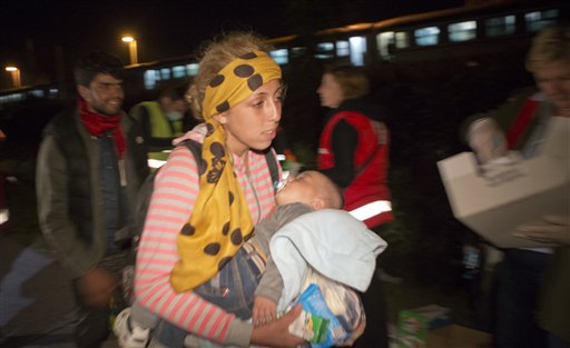 Migrants walk towards Hungary after arriving by train in Botovo Croatia on the Hungarian border Tuesday Sept. 22 2015. At a contentious meeting European Union ministers agreed Tuesday to relocate 120,000 refugees among the bloc to ease the strains