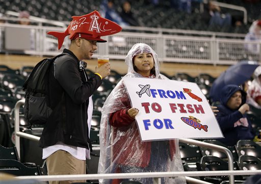 Fans of Los Angeles Angels&#039 Mike Trout wait during a rain delay prior to a baseball game between the Angels and Minnesota Twins Friday Sept. 18 2015 in Minneapolis