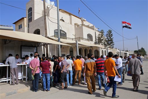 Syrian refugees gather outside their embassy waiting to apply for passports or to renew their old ones in Amman Jordan. Hundreds of Syrian refugees line up at their country's embassy every day for a long shot