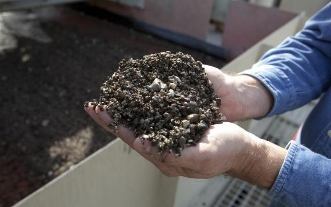 Mike James an employee of Mosaic Co holds phosphate pebbles as it comes off the grading screens at Mosaic's South Fort Meade Mine in Fort Meade Florida in this