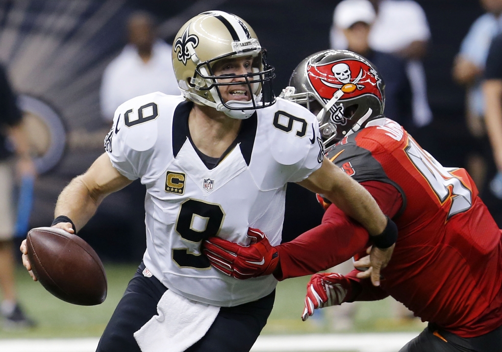 New Orleans Saints quarterback Drew Brees scrambles under pressure from Tampa Bay Buccaneers defensive end George Johnson in the first half of an NFL football game in New Orleans. The Saints have fallen