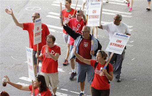 Striking Seattle School District teachers and other educators wave to motorists as they walk a picket line Thursday Sept. 10 2015 in front of Franklin High School in Seattle. The strike was called when Seattle Public Schools and the teachers union