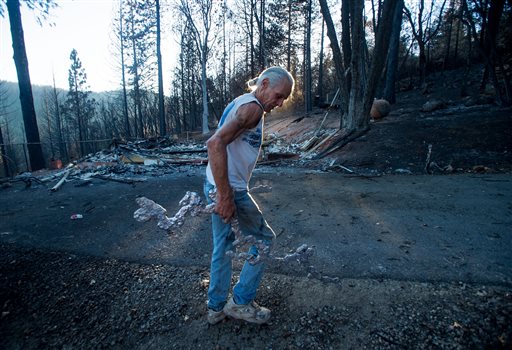 J.D. Roel salvages a scrap of melted metal from a friend's property after a wildfire raged through the Loch Lomond area of Lake County Calif. Monday Sept. 21 2015. Gov. Jerry Brown requested a presidential disaster declaration on Monday noting