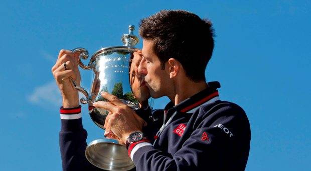 Novak Djokovic of Serbia poses with the championship trophy in Central Park the day after winning the 2015 U.S. Open tennis tournament