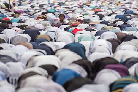 Chinese Muslims perform morning prayers on the street near a mosque in Shanghai on Sept. 24. The Communist Party has moved to solidify its control over religions with new regulations managing relations with different faiths