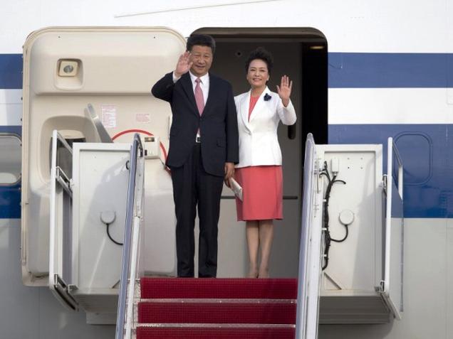 Chinese President Xi Jinping and his wife Peng Liyuan wave as they arrive in Andrews Air Force Base on Thursday en route to Washington for a State Visit