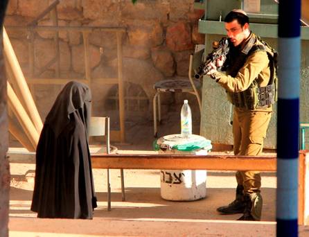 An Israeli soldier aims his rifle at a woman said to be 19-year-old Palestinian student Hadeel al-Hashlamun before she was shot and killed by Israeli troops