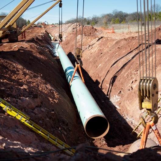 A sixty-foot section of pipe is lowered into a trench during construction of the Gulf Coast Project pipeline in Prague Oklahoma U.S. on Monday