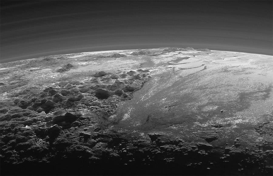 NASA’s New Horizons spacecraft looked back toward the sun and captured this near-sunset view of the rugged icy mountains and flat