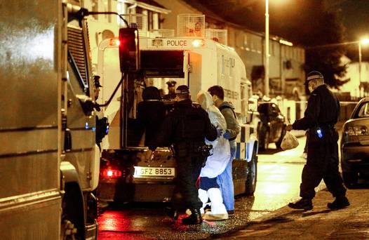 Police officers make arrests after the arms and explosives find in west Belfast last Friday