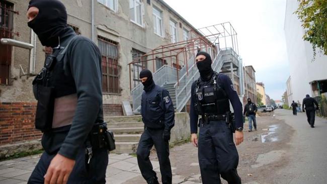 German special police members walk during a raid on a piece of property in Berlin Germany