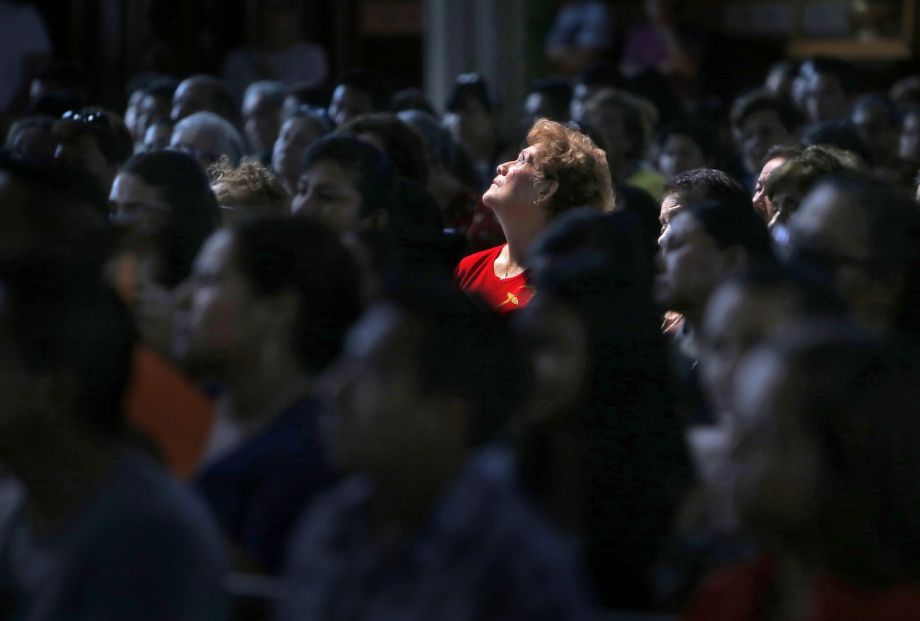 Lupe Mendoza looks up as San Francisco Archbishop Salvatore Cordileone officiates at a Sunday Mass for St. Peter Catholic Church parishioners who are traveling to Washington D.C. to see Pope Francis