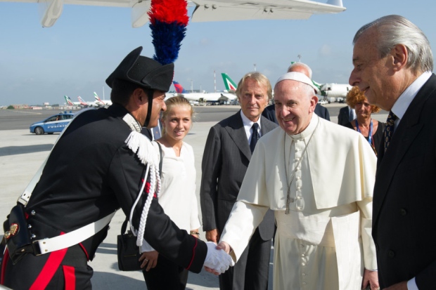 Pope Francis shakes hands with an Italian police officer yesterday before boarding his flight to Cuba