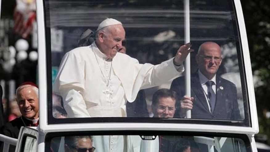 Pope Francis waves from the popemobile during a parade in Washington