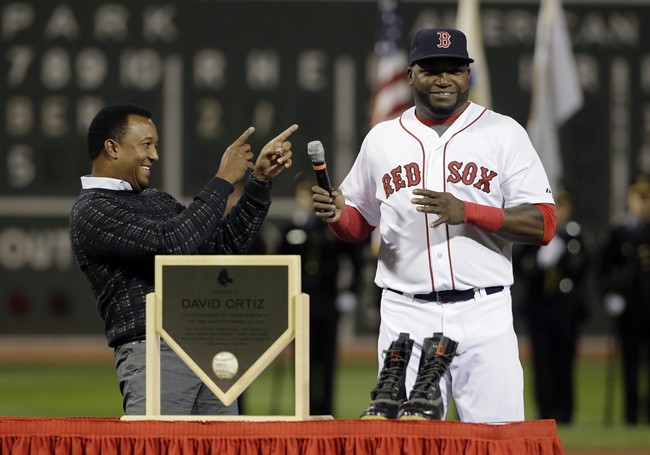 Former Boston Red Sox pitcher Pedro Martinez left smiles and points toward Red Sox's David Ortiz as Ortiz takes the microphone during ceremonies held to honor his 500 career home runs before a baseball game against the Tampa Bay Rays Monday Sept. 21