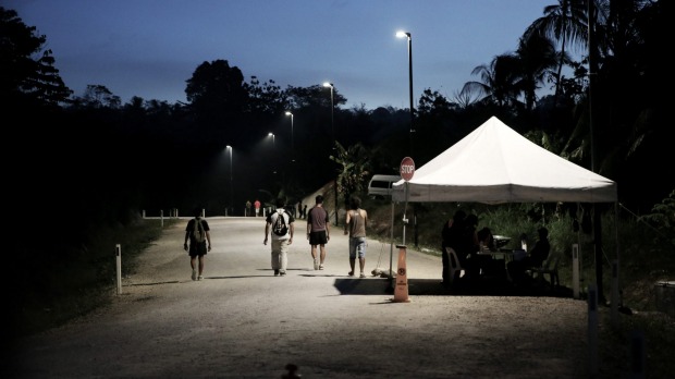 Refugees pass the security check point as they return to the East Lorengau Transit Centre on Manus Island