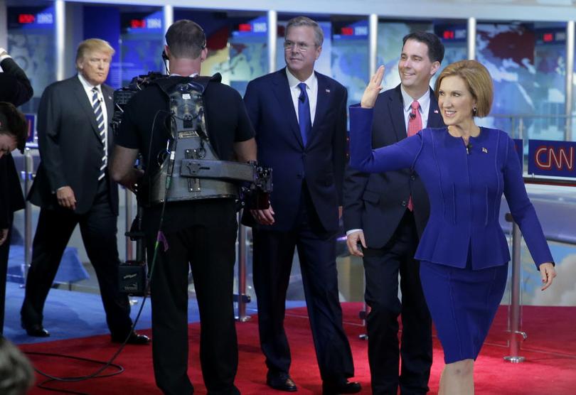 Republican presidential candidate businesswoman Carly Fiorina right leads fellow candidates Scott Walker second from right Jeb Bush center and Donald Trump as they take the stage prior to the CNN Republican presidential debate at the Ronald Reagan