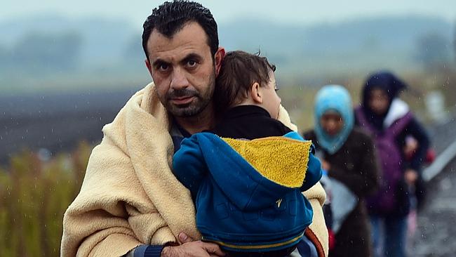 A migrant family arrives to Hungary in a rainy weather at the Hungarian Serbian border