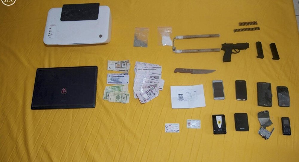 Devices along with money and pistol said to be seized by Saudi security forces after arresting suspected Islamic State militants are seen in this handout