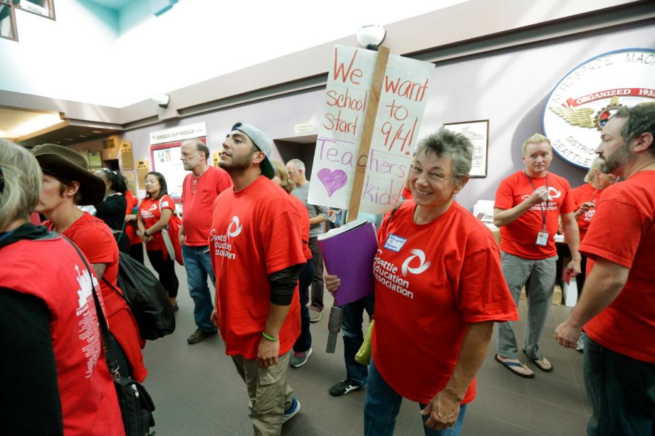 Margaret Gingrich a second-grade teacher at Montlake Elementary school carries a picket sign as she and other members of the Seattle Education Association the union that represents striking teachers from the Seattle School District file into a meeting