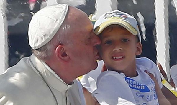 Pope Francis kisses a boy as he arrives