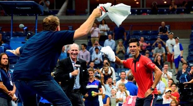 Novak Djokovic of Serbia dances on the court with a fan after defeating Andreas Haider Maurer of Austria during their US Open 2015 second round men's singles match at the USTA Billie Jean King National Center