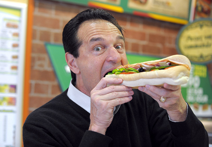 U.S. sandwich maker Subway co-founder Fred De Luca poses with a sandwich in a Parisian Subway restaurant