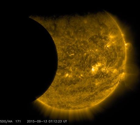 This Sept. 13 2015 image provided by NASA shows the moon left and the Earth top transiting the sun together seen from the Solar Dynamics Observatory. The edge of Earth appears fuzzy because the atmosphere blocks different amounts of light at differe