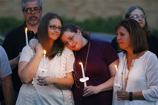 Liz Schmidt widow of Delta State University history professor Ethan Schmidt who was murdered by a colleague in his office Monday is comforted by friends Jenn Westmoreland center and Amy Cotrell during a candlelight memorial in his honor on the Clevela