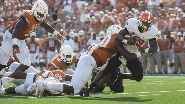 Rennie Childs #23 of the Oklahoma State Cowboys is wrapped up by the Texas Longhorns during the 3rd quarter