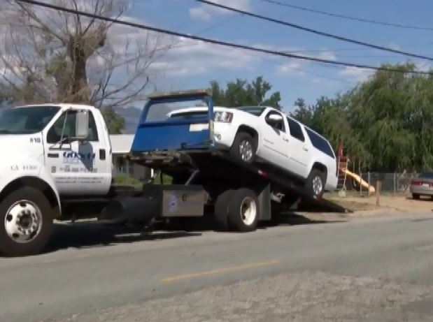 The white SUV driven by the suspect in a series of deadly shootings Saturday in Banning CA is loaded onto a wrecker