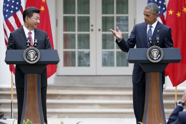 President Barack Obama gestures toward Chinese President Xi Jinping during their joint news conference in the Rose Garden of the White House in Washington Friday