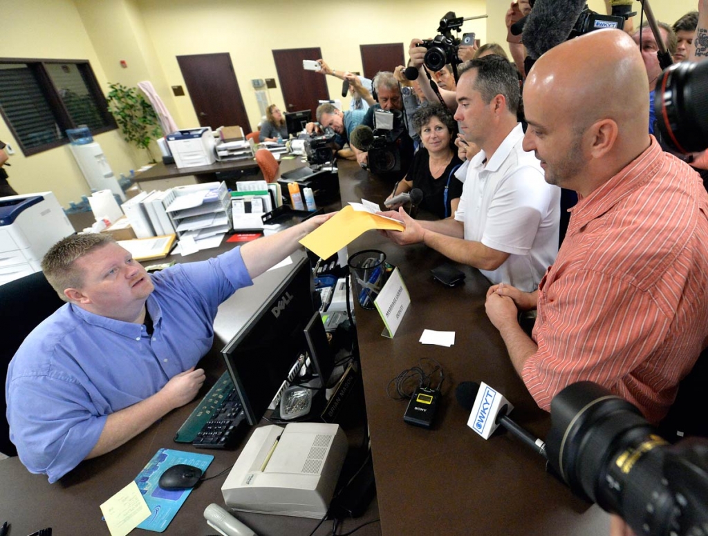 Rowan County deputy clerk Brian Mason left hands James Yates and his partner William Smith Jr. their marriage license at the Rowan County Judicial Center in Morehead Ky. Friday Sept. 4 2015