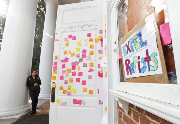 A University of Virginia student looks over postings on the door of Peabody Hall related to the Phi Kappa Psi gang rape allegations at the school in Charlottesville Virginia Monday Nov. 24 2014