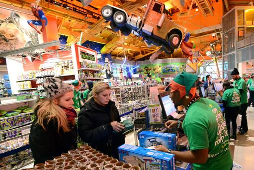 Shoppers purchase items at Toys-R-Us in Times Square on Thanksgiving night in New York U.S. on Thursday Nov. 28 2013. Toys-R-Us in Times Square opened at 4pm on Thanksgiving day to accommodate early Black Friday shoppers