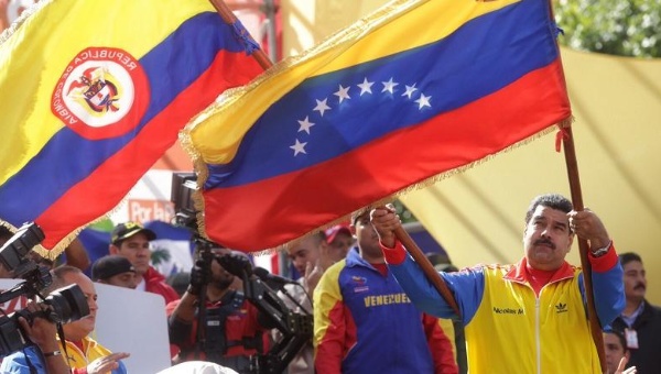 Venezuelan President Nicolas Maduro waves the flags of Colombia and Venezuela during a rally against paramilitarism in Caracas Venezuela