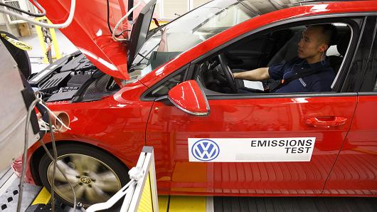 A worker tests a red 2016 Volkswagen AG Golf TDI emissions certification vehicle inside the California Air Resources Board Haagen Smit Laboratory in El Monte California